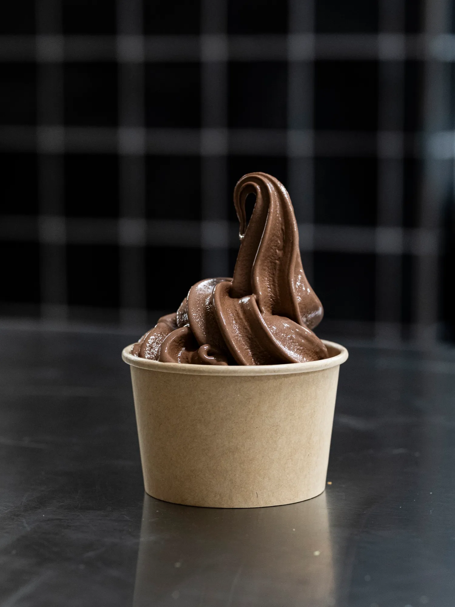 A swirl of Belgian chocolate gelato in a kraft paper cup