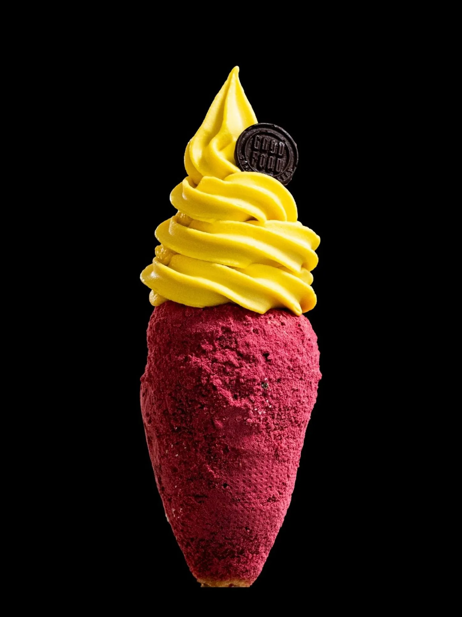 A raspberry-dusted chimney cone filled with a tall swirl of bright yellow mango gelato