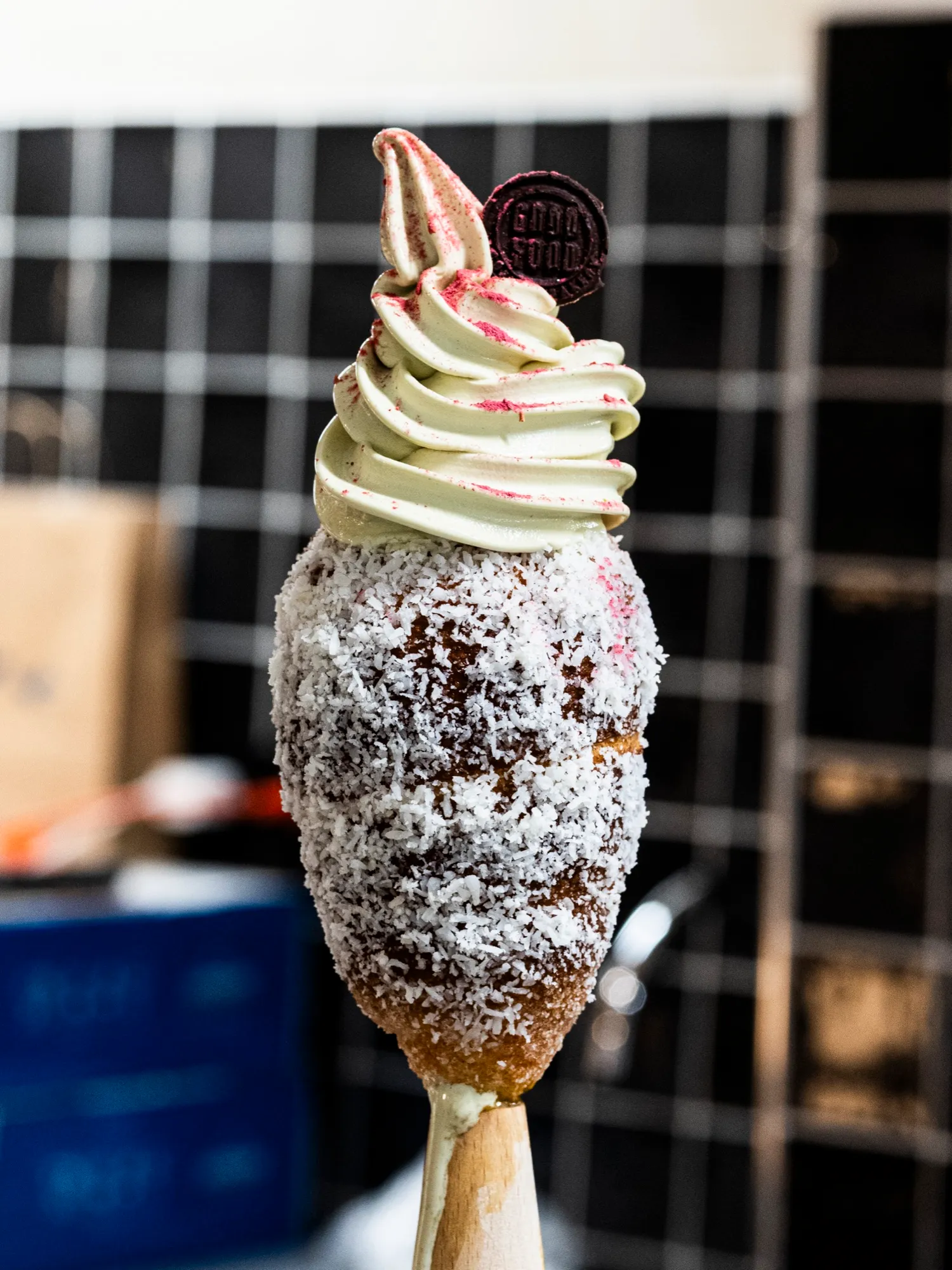 A coconut chimney cone with pistachio gelato dusted in raspberry