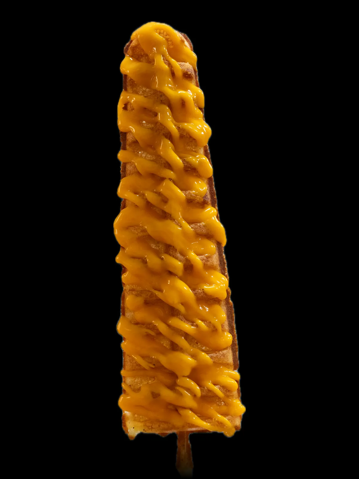 A waffle on a stick covered in cheese sauce