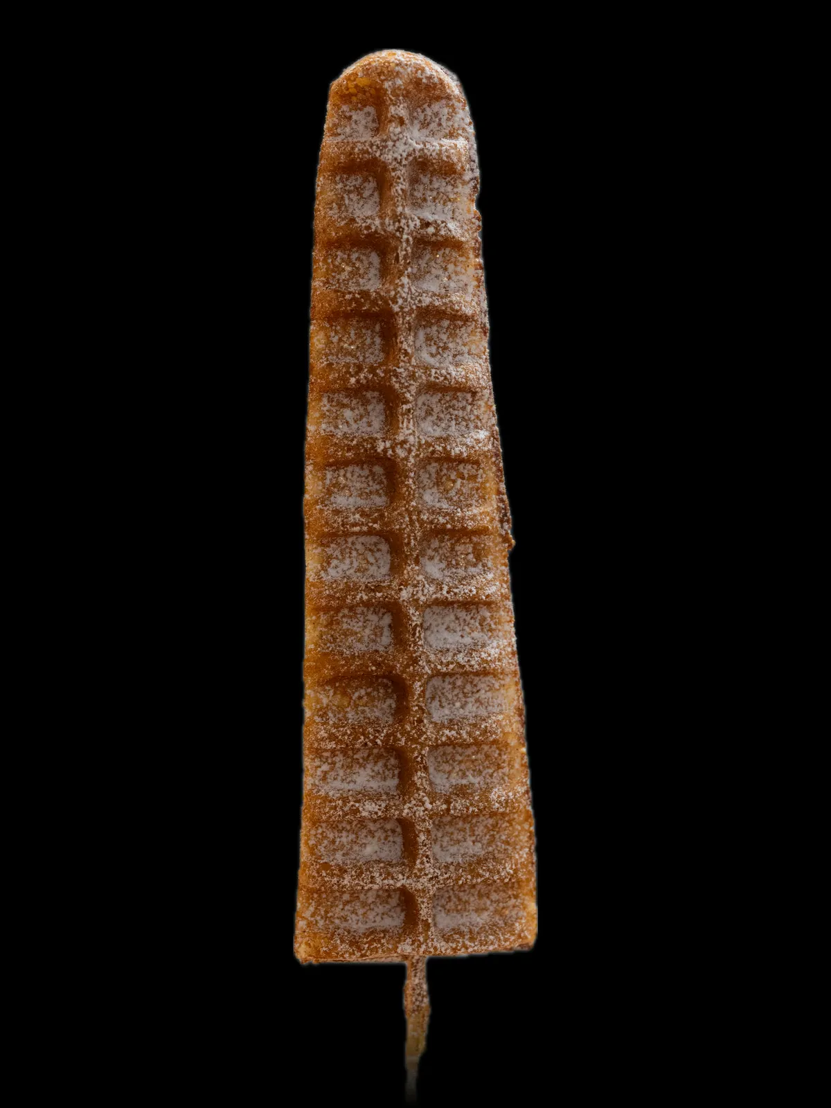 A ridged waffle on a stick coated in cinnamon sugar