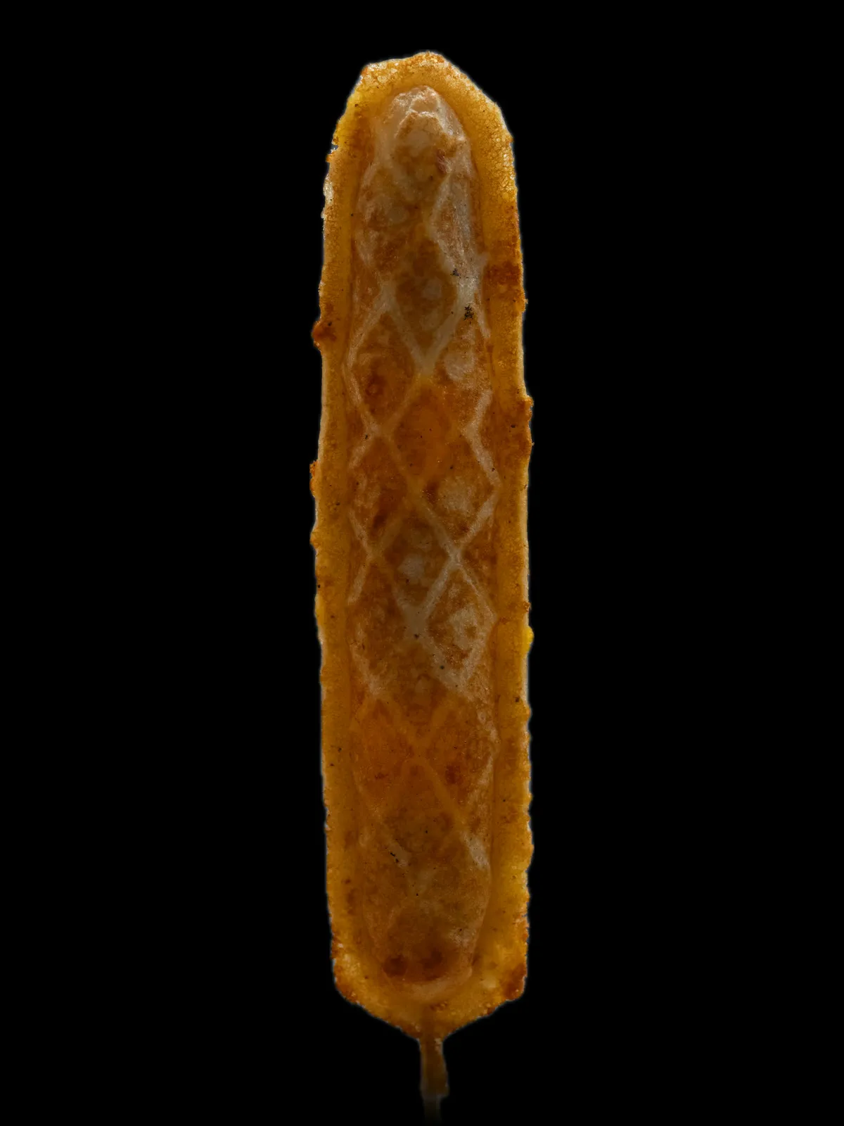 A long golden waffle on a stick with sausage and cheese baked inside