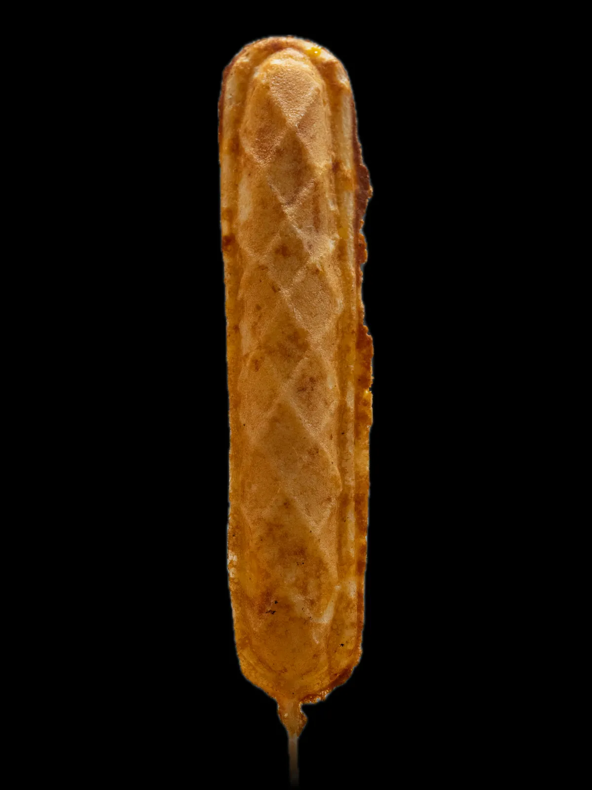 A long golden waffle on a stick with a sausage baked inside